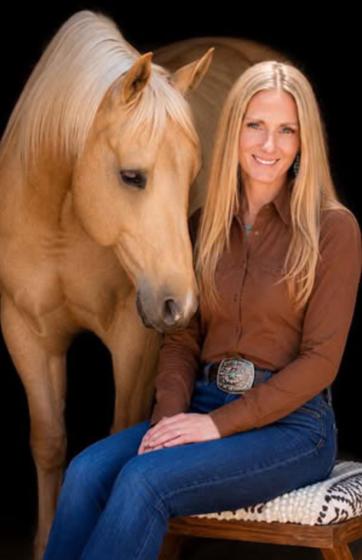 Michelle Enos, Registered Associate Marriage and Family Therapist, sitting beside a palomino horse